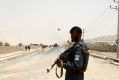 An Afghan policeman stands guard near to the site of a suicide bomber, who struck at a NATO convoy in Kandahar southern ...