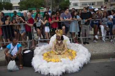 A member of a samba school sits on the sidewalk before parading along Copacabana Beach in Rio de Janeiro, Brazil. ...