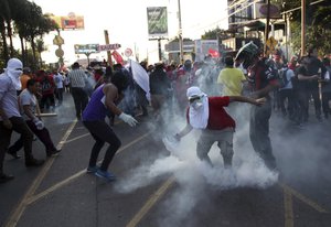 Supporters of opposition presidential candidate Salvador Nasralla throw back a tear gas canister at the police during clashes near Presidential House in Tegucigalpa, Honduras, Friday, Jan. 12, 2018.