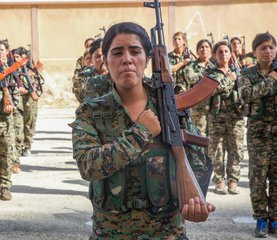 File - Syrian Democratic Forces trainees, representing an equal amount of Arab and Kurdish volunteers, stand in formation at their graduation ceremony in northern Syria, Aug. 9, 2017.