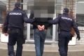 Serbian authorities handcuff one of three Australian men arrested in a Belgrade hotel in connection to a cocaine importation.