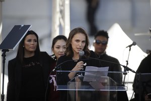 Actress Natalie Portman, right, speaks as she is joined by Eva Longoria, background left, and Constance Wu at a Women's March against sexual violence and the policies of the Trump administration Saturday, Jan. 20, 2018, in Los Angeles.