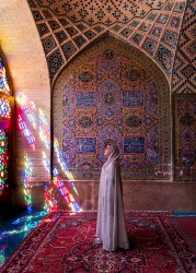 A woman bathes in the morning light in one of Iran's most beautiful mosques the Nasir Al-Mulk Mosque in Shiraz which is ...