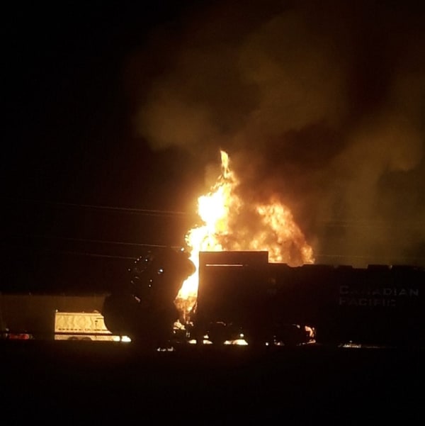 Un train dans une gare dans le noir, un feu tout près