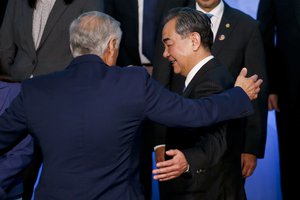 Chile's Foreign Minister Heraldo Munoz, left, embraces China's Foreign Minister Wang Yi after posing for a group picture on the sidelines of the second ministerial that is part of a forum between China and the Community of Latin American and Caribbean States (CELAC) in Santiago, Chile, Monday, Jan. 22, 2018.