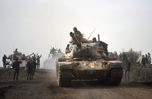 Turkish army tanks enter Afrin, an enclave in northern Syria controlled by U.S.-allied Kurdish fighters, in Hassa, Hatay, Turkey, Monday, Jan. 22, 2018.