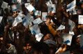 REFUGEE DAILY LIFE Men and boys hold their ration cards in the air at a Red Cross distribution point in Burma Para ...