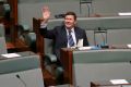 Father of the House Kevin Andrews waves to the public gallery in Parliament House.