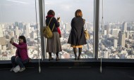 Visitors take selfies and pictures of the Tokyo skyline from the Roppongi Hills commercial complex on January 20, 2018. Photo: AFP / Behrouz MEHRI