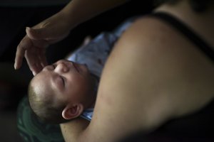 In this Dec. 16, 2016 file photo, Puerto Rico resident Michelle Flandez caresses her two-month-old son, Inti Perez, diagnosed with microcephaly linked to the mosquito-borne Zika virus, in Bayamon, Puerto Rico.