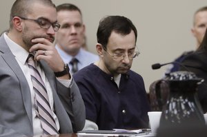 Larry Nassar sits with attorney Matt Newburg during his sentencing hearing Wednesday, Jan. 24, 2018, in Lansing, Mich. The former sports doctor who admitted molesting some of the nation's top gymnasts for years was sentenced Wednesday to 40 to 175 years in prison as the judge declared: "I just signed your death warrant."