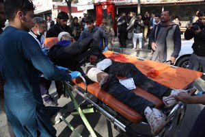 An injured man arrives outside a hospital following a suicide attack in Kabul, Afghanistan