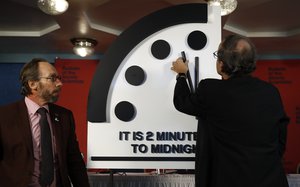 Robert Rosner, chairman of the Bulletin of the Atomic Scientists, right, joined by Bulletin of the Atomic Scientists member Lawrence Krauss, left, moves the minute hand of the Doomsday Clock to two minutes to midnight during a news conference at the National Press Club in Washington, Thursday, Jan. 25, 2018.