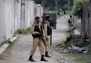 FILE - In this May 5, 2011 photo, Pakistani army troops guard the perimeter of the walled compound of a house where al-Qaida leader Osama bin Laden was caught and killed by U.S. forces in Abbottabad, Pakistan.