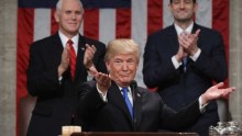 Donald Trump gestures and shrugs at a podium