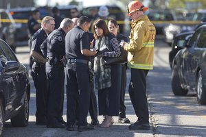 Los Angeles Fire department's Erik Scott, far right, police officers and school officials gather outside the Belmont High School in Los Angeles Thursday, Feb. 1, 2018.