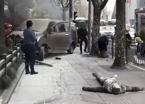 EDS NOTE: GRAPHIC CONTENT In this image taken from cellphone video provided to the Associated Press, rescuers attend to victims after a minivan carrying gas tanks plowed into pedestrians along a street in Shanghai, Friday, Feb. 2, 2018.