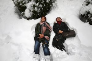 Two women lie on the snow in Mellat Park in northern Tehran, Iran, Sunday, Jan. 28, 2018. While Iran's first heavy ...