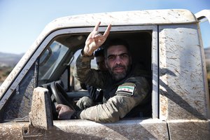 Turkey-backed Syrian opposition fighters of the Free Syrian Army drive towards the border with Syria, in the outskirts of the border town of Kilis, Turkey, Tuesday, Jan. 30, 2018.