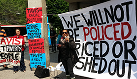 Anti-police protest at Dundas and Sherbourne. Speaker in front of banner that says "We will not be policed, priced or pushed out"