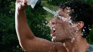 Young exhausted athlete splashing and pouring fresh water on his head to refresh during a running trail Wrong keywords? ...