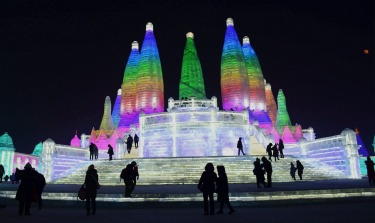 Visitors walk among the attractions at the Harbin International Ice and Snow Sculpture Festival in Harbin in ...