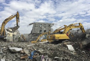 In this February 11, 2016 file photo, rescue teams use heavy excavation machinery to dig through the rubble of a collapsed building complex in Tainan, Taiwan