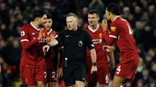 Referee Johnathan Moss awards the second penalty as Liverpool players react during the English Premier League soccer ...