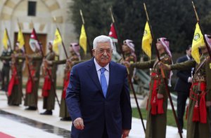 Palestinian President Mahmoud Abbas reviews an honor guard on his arrival to the Royal Palace, in Amman, Jordan, Monday, Jan. 29, 2018.