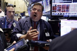 Trader John Santiago, center, works on the floor of the New York Stock Exchange, Monday, Aug. 24, 2015. U.S. stock markets plunged in early trading Monday following a big drop in Chinese stocks.