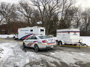 In this Saturday, Feb. 3, 2018 photo, police vehicles are parked outside a property where they say they have recovered the remains of at least six people from planters on the property which is connected to alleged serial killer Bruce McArthur, in Toronto, Canada.