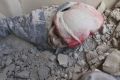 A child partly buried in rubble after airstrikes hit a rebel-held suburb near Damascus.