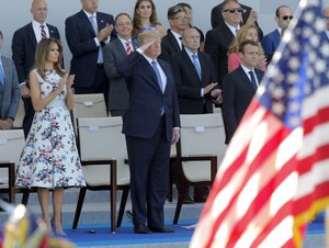 French President Emmanuel Macron, right, U.S. President Donald Trump and U.S. First Lady Melania Trump watch the traditional Bastille Day military parade on the Champs Elysees, in Paris, Friday, July 14, 2017.