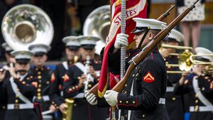 File - Marine Corps color guard members march onto a parade deck during the Marine Week opening ceremony in Detroit, Sept. 6, 2017.