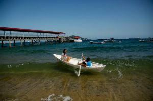 Children play with a row boat in Taboga Island, Panama, Friday, Jan. 26, 2018. Taboga, also known as the "Island of ...