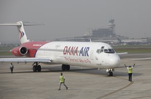 In this Friday, Jan. 4, 2013 file photo, Dana airline ground staff signal to the pilot during a demonstration Lagos- Abuja flight with celebrities, journalists and the airline executives at the Murtala Muhammed airport in Lagos, Nigeria