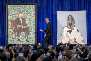 Former President Barack Obama, center, stands on stage during the unveiling of the Obama's official portraits at the Smithsonian's National Portrait Gallery, Monday, Feb. 12, 2018, in Washington.