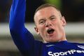 Everton's Wayne Rooney, left. celebrates scoring his side's third goal of the game during the English Premier League ...