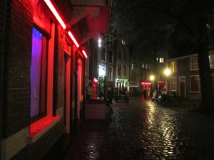 File - The red light district De Wallen, near the Oude Kerk, in Amsterdam, Holland, where prostitutes offer their sexual services from behind a window or glass door.