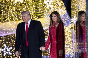 President Donald Trump and first lady Melania Trump stand on stage after lighting the 2017 National Christmas Tree on the Ellipse near the White House, Thursday, Nov. 30, 2017, in Washington. (AP Photo/Andrew Harnik)