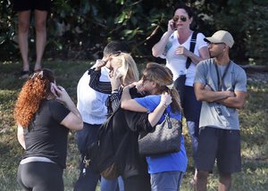 Anxious family members hug students, Wednesday, Feb. 14, 2018, in Parkland, Fla.