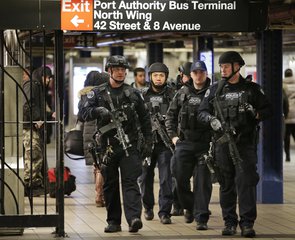 Heavily armed police officers patrol near the site of a terror attack in the subways under Port Authority Bus Terminal in New York, Tuesday, Dec. 12, 2017.