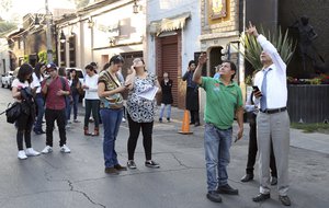 People stands in the street as an earthquake shakes Mexico City, Friday, Feb. 16, 2018.