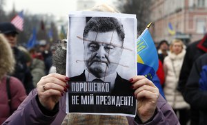 A protester holds President Petro Poroshenko's photo demanding his impeachment at a rally in central Kiev, Ukraine