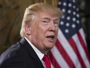 President Donald Trump turns to talk to the gathered media during a Christmas Eve video teleconference with members of the mIlitary at his Mar-a-Lago estate in Palm Beach, Fla., Sunday, Dec. 24, 2017.