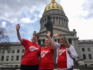 Striking teachers Michelle Myers, left, Holly O’Neil, center, and Suzanne Varner of McNinch Primary School in Moundville, W.Va. wave to passing cars outside the state Capitol in Charleston, W.Va, Friday, Feb. 23, 2018.