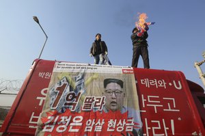 A South Korean protester burns a North Korean flag during a rally against a visit of Kim Yong Chol, vice chairman of North Korea's ruling Workers' Party Central Committee, near the Unification bridge in Paju, South Korea, Sunday, Feb. 25, 2018.