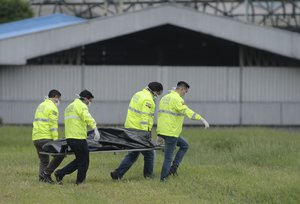 Police transport the body of one of the two stowaways that apparently fell from an airplane to the runway of the Jose Joaquin de Olmedo airport in Guayaquil, Ecuador, Monday, Feb. 26, 2018.