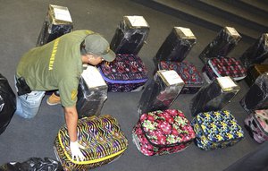 In this photo taken on Dec. 14, 2016, and released on Feb. 22, 2018, by the Argentine Security Ministry, a police officer guards suitcases that carried cocaine, that were found in an annex building of the Russian embassy in Buenos Aires, Argentina.