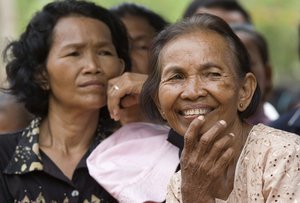 Im Chaem, right, 67-year-old former Khmer Rouge provincial secretary, reacts as she witnesses delivery of copies of "A History of Democratic Kampuchea" to students in Anlong Veng, in Uddor Mean Chey province, about 300 kilometers (185 miles) north of Phnom Penh, Cambodia, Monday, June 21, 2010. Cambodian students in the former Khmer Rouge stronghold were issued the textbook Monday that for the first time teaches the atrocities of the past, a little more than a decade after government forces captured the movement's last bastion.